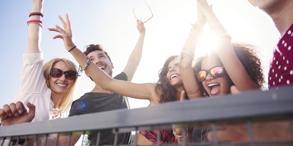 Festval Goers | Excited group of friends celebrating on a balcony in Liverpool.